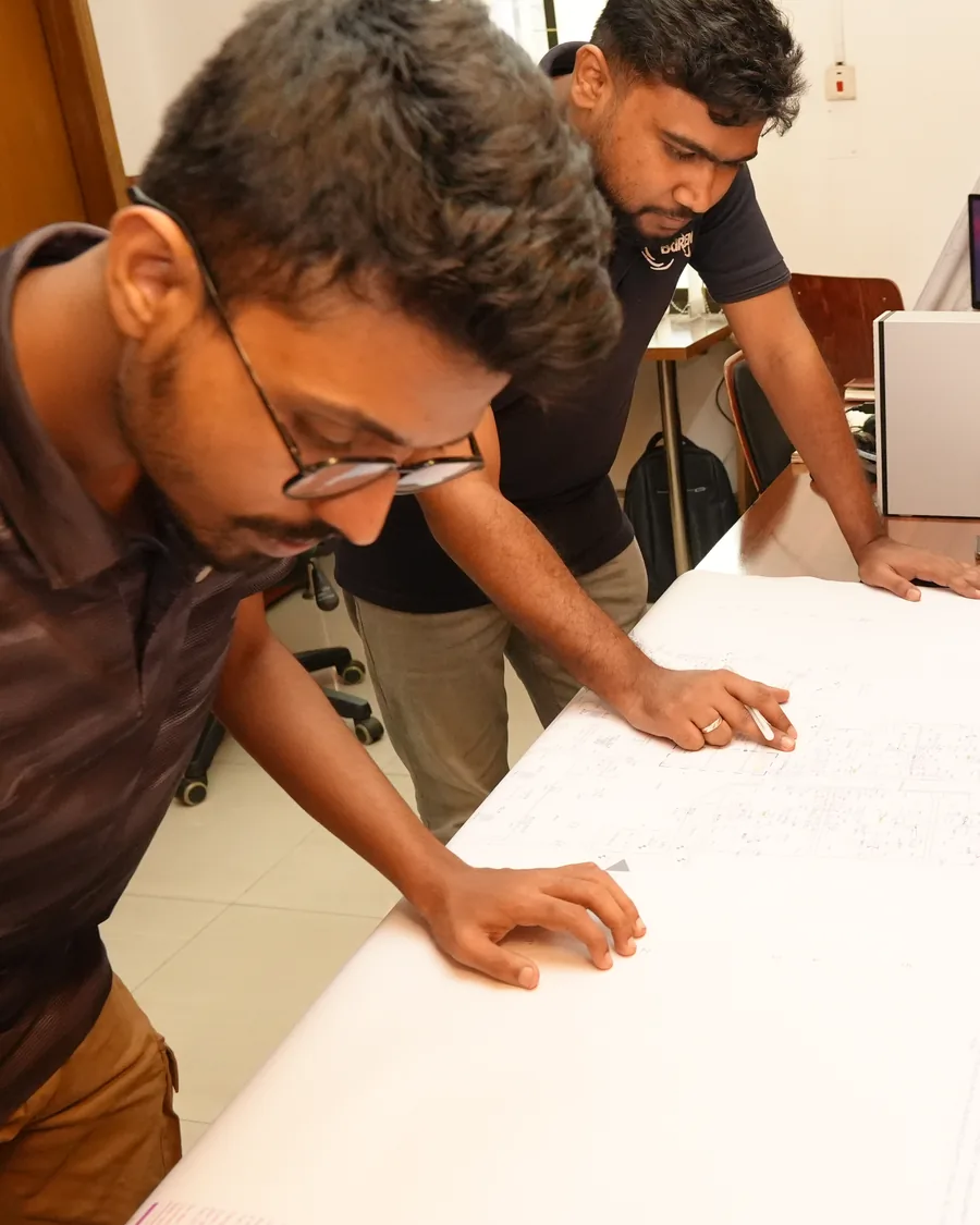 Two Zesterex engineers checking a marked-up drawing set