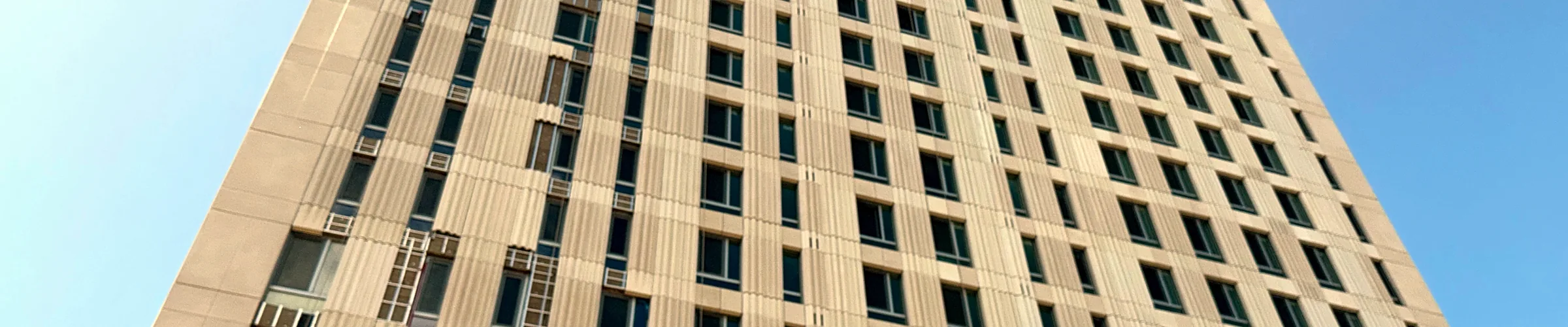 Facade of a multifamily tower in New York, looking up from the street
