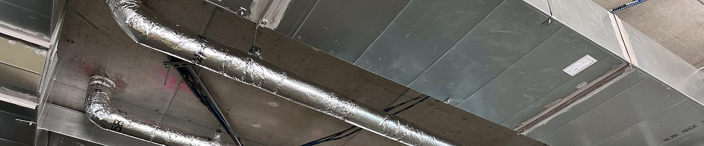 Insulated ductwork and piping at ceiling level on a New York project