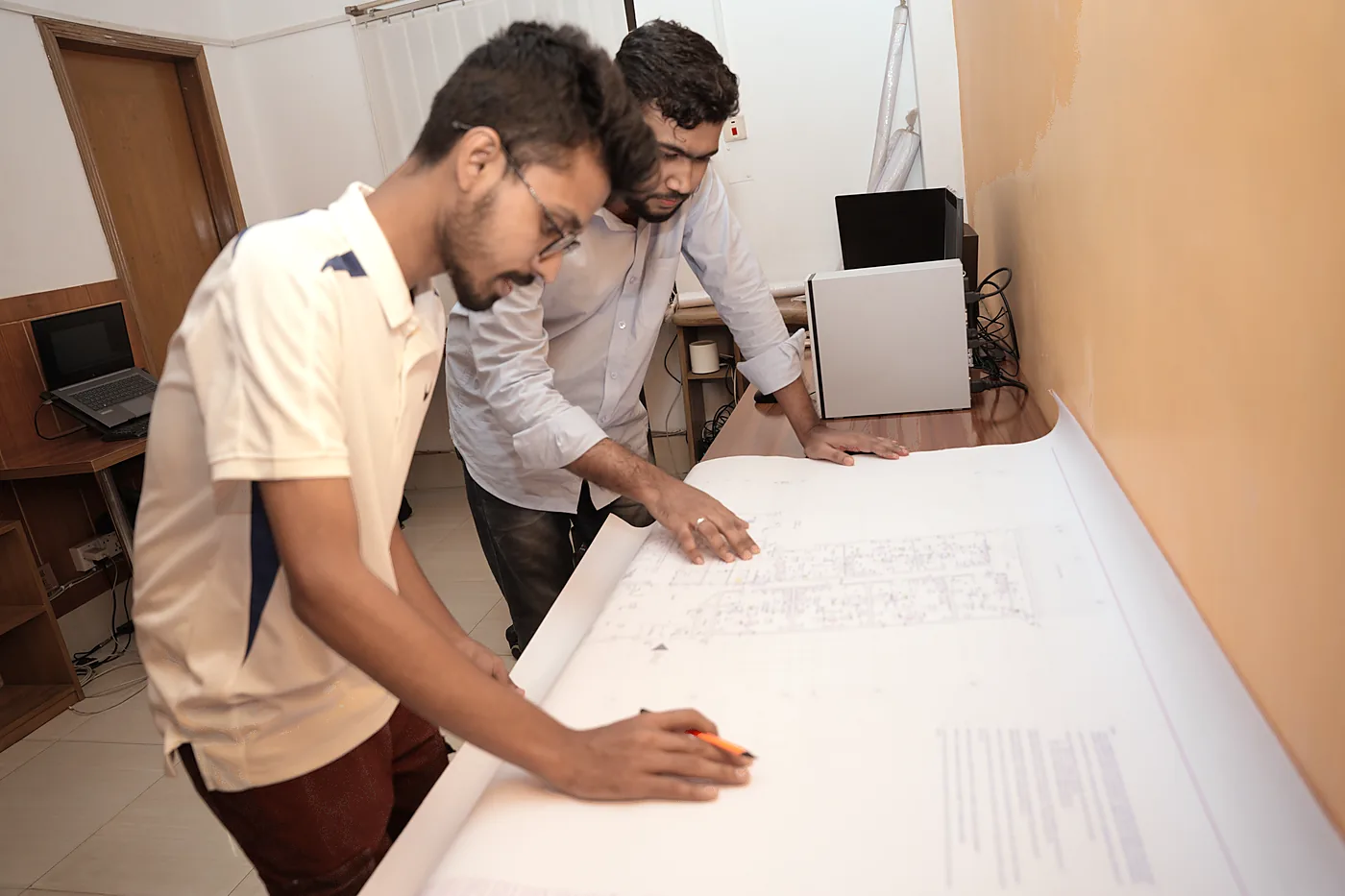 Two Zesterex engineers marking up a drawing set together