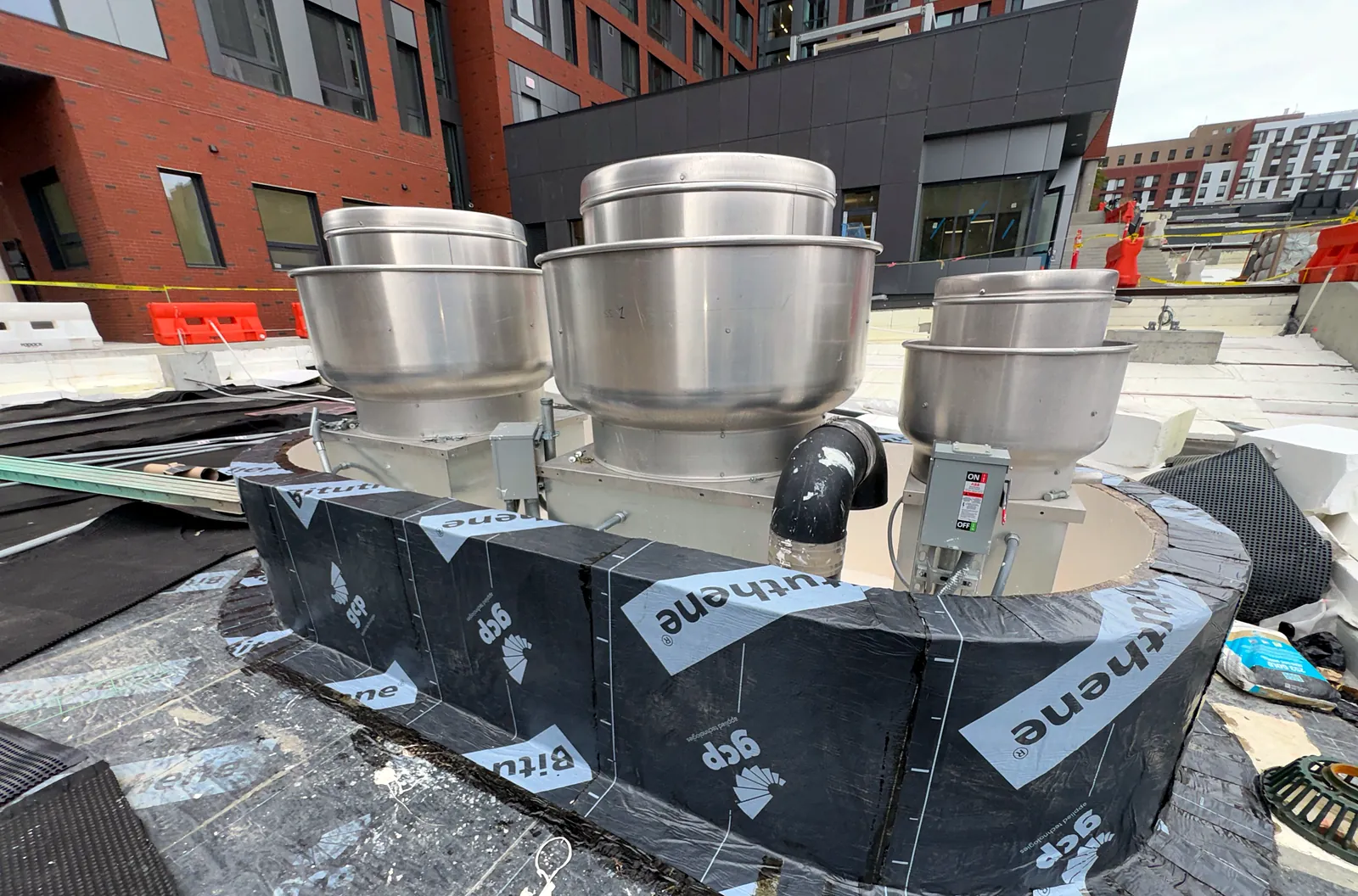 Rooftop exhaust fans on curbs during roofing