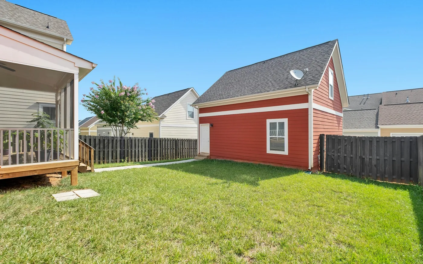 A detached backyard accessory dwelling unit behind a house
