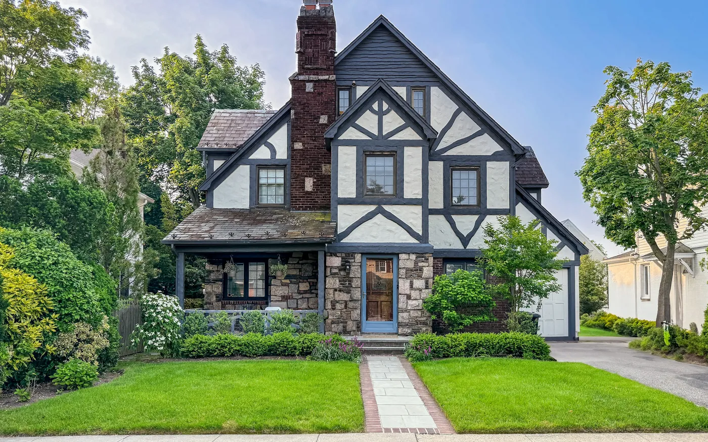 A two-storey single-family house with a front lawn